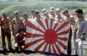 American soldiers display captured Japanese flag on Guadalcanal
